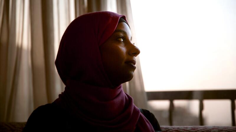 A woman is looking out of a window