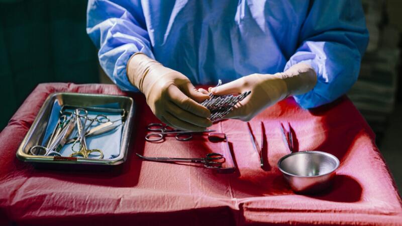 A doctor preparing surgical instruments