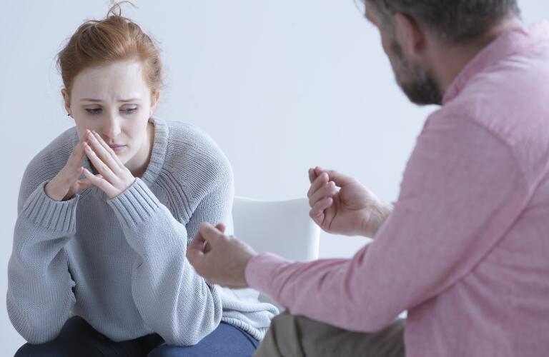 Young Caucasian woman looking sad with therapist