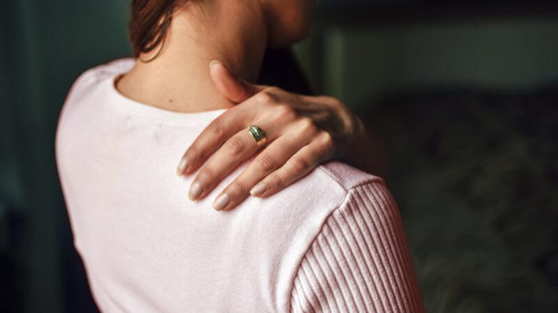 Person with hand on their shoulder
