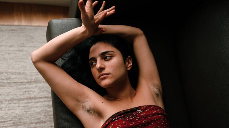 a woman is lying on a sofa with her arms above her head