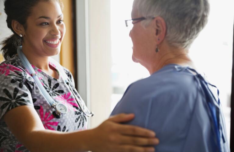 Young female doctor comforting patient in clinic