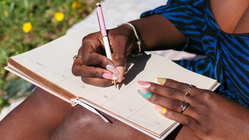 A person writes in a diary showing the days of the week.