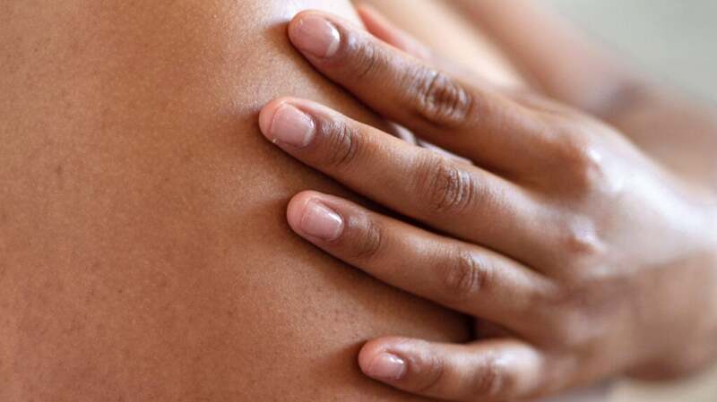 A close-up of someone placing their hand over their skin.