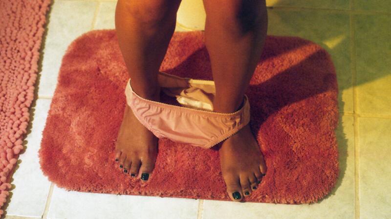 there is a person with pink underwear standing on a red bath mat