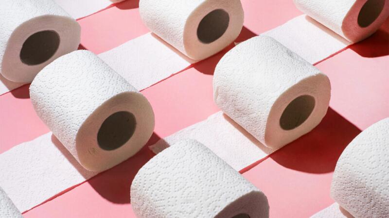 There is a pattern of toilet paper against a pink background.