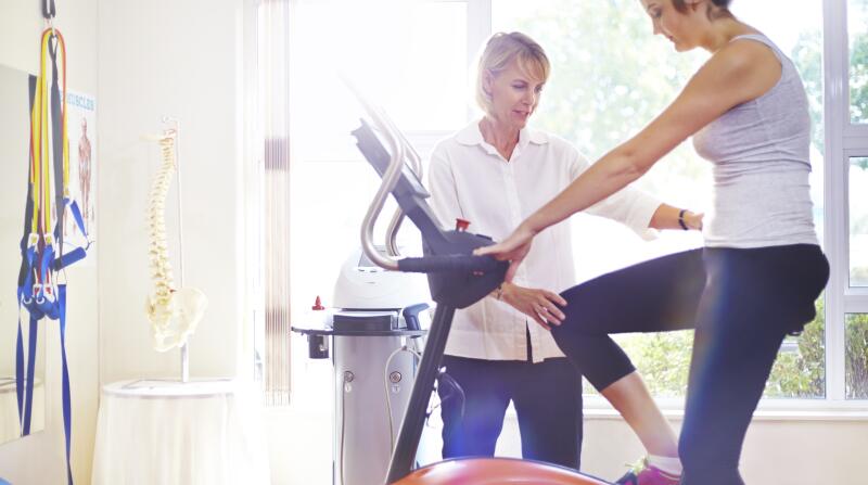 physical-therapist-with-patient-on-stationary-bike