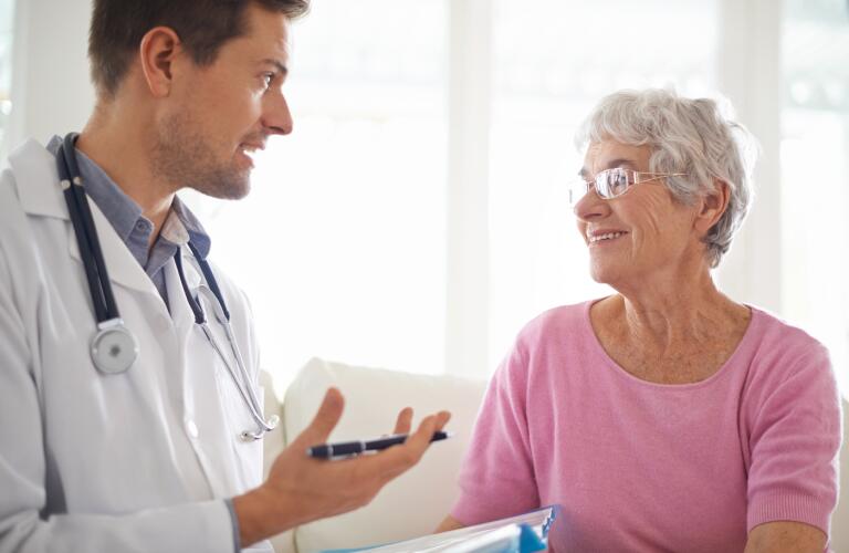 smiling-senior-woman-chatting-with-her-GP-during-an-appointment