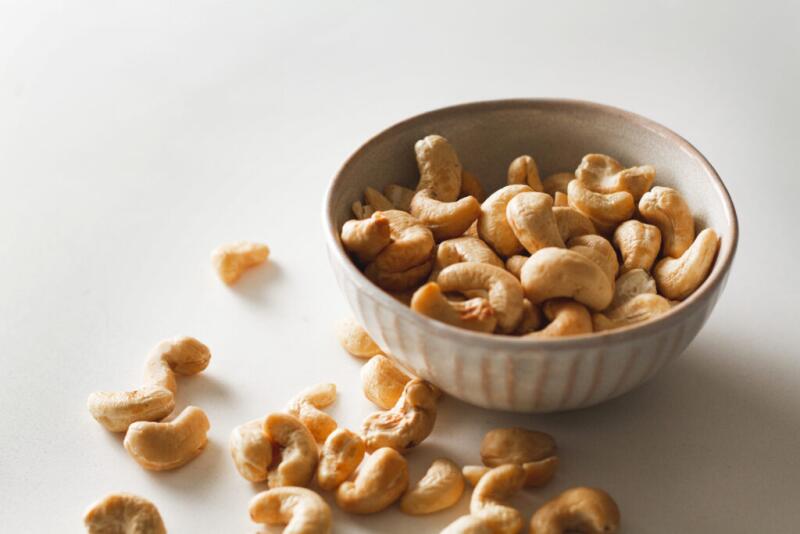 A bowl of cashews on a plain white background.