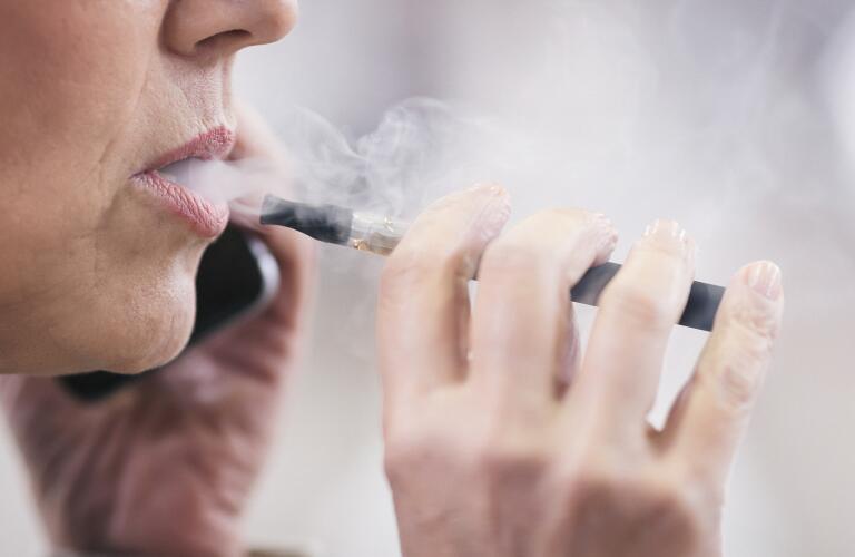 closeup of senior Caucasian woman vaping with electronic cigarette