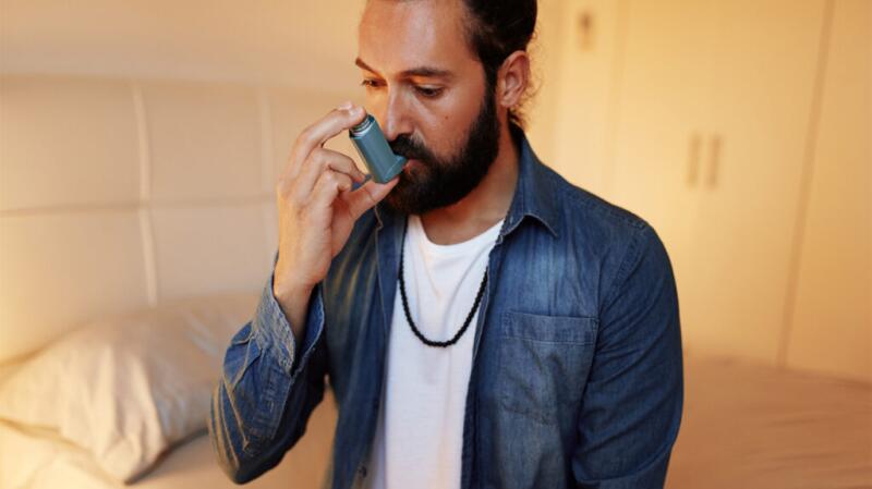 a person with asthmatic bronchitis is using an inhaler