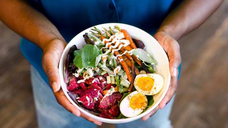 a person is holding a bowl of salad