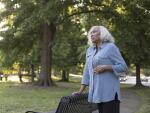 Senior African American woman in park with hand on stomach