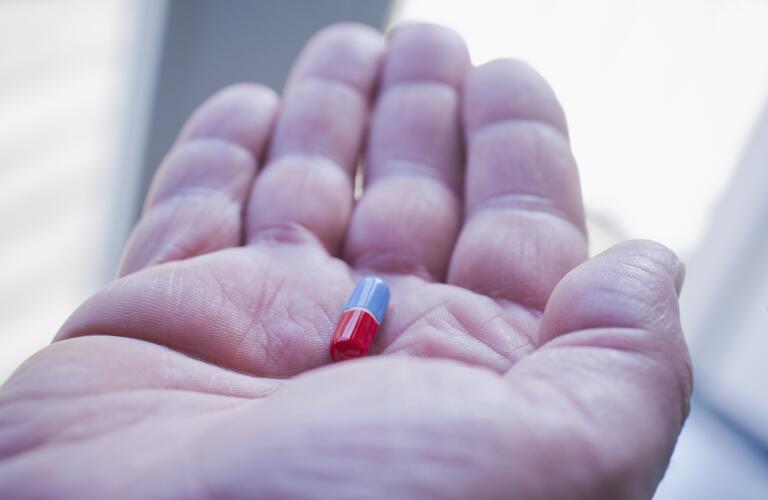 close up of hand holding pill