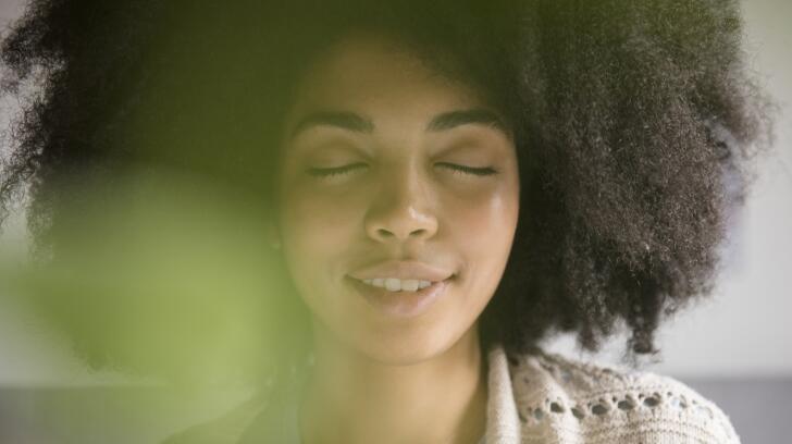 Close-up of African American woman meditating with eyes closed