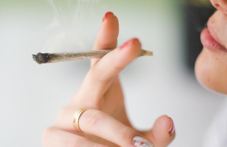 Close-up of Caucasian woman smoking marijuana joint