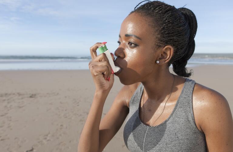 woman-on-beach-using-inhaler