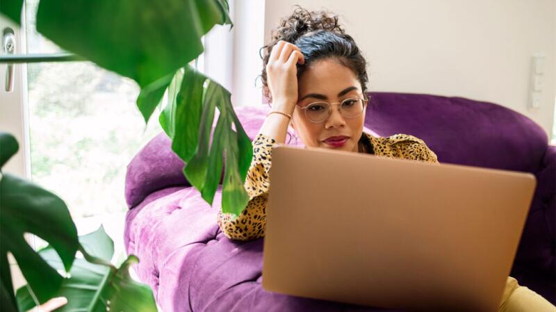A woman is looking at her laptop