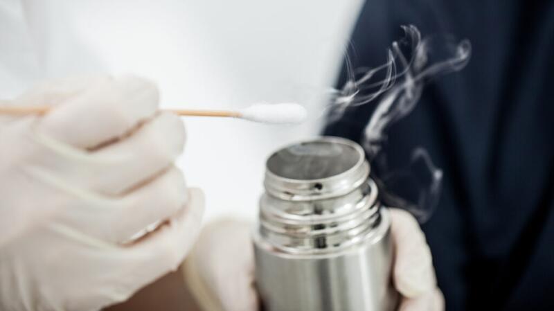 Person with gloved hands holding a cryosurgery canister and applicator.