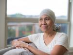 cancer patient sitting by window in head wrap