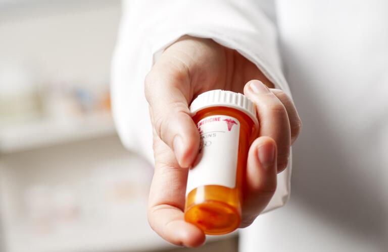 pharmacist-holding-a-bottle-of-prescription-medicine