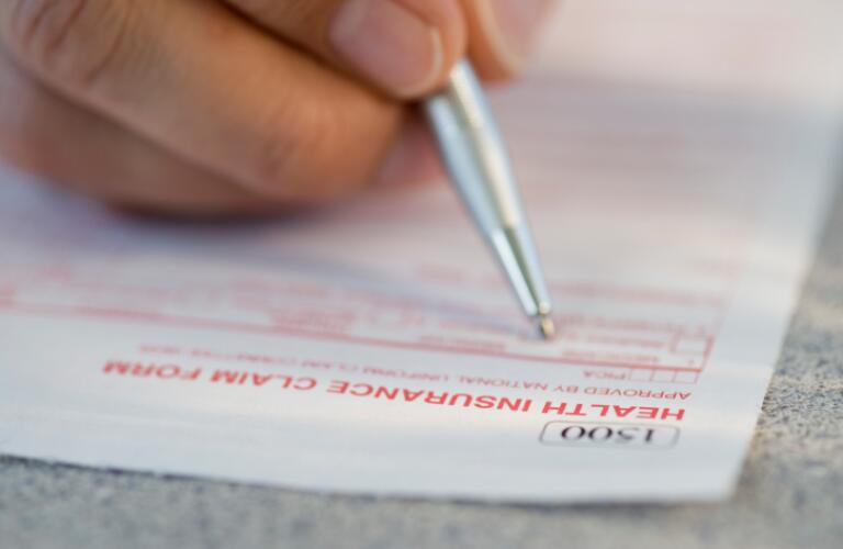 Man Filling out Insurance Claim Form