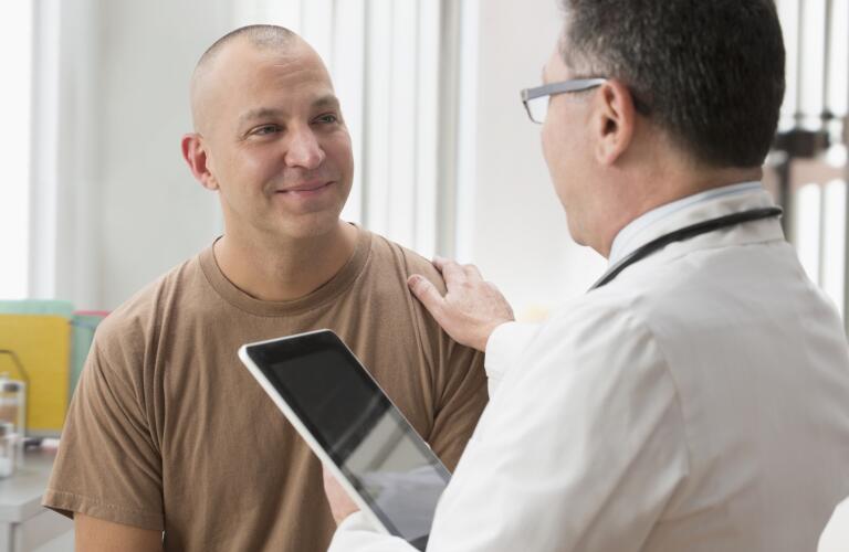 Caucasian soldier and doctor talking in office