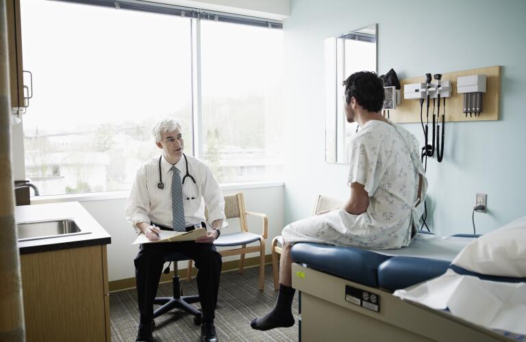 Male patient and doctor in discussion in exam room
