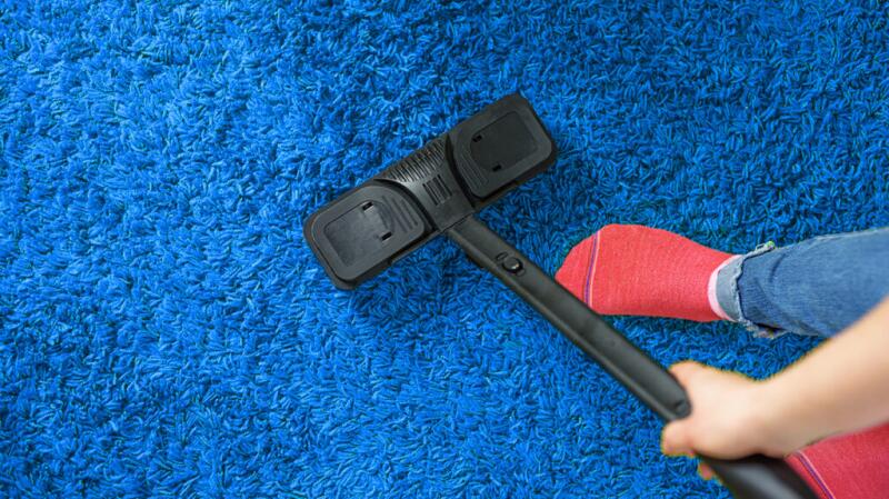 a person is vacuuming their home to prevent mites