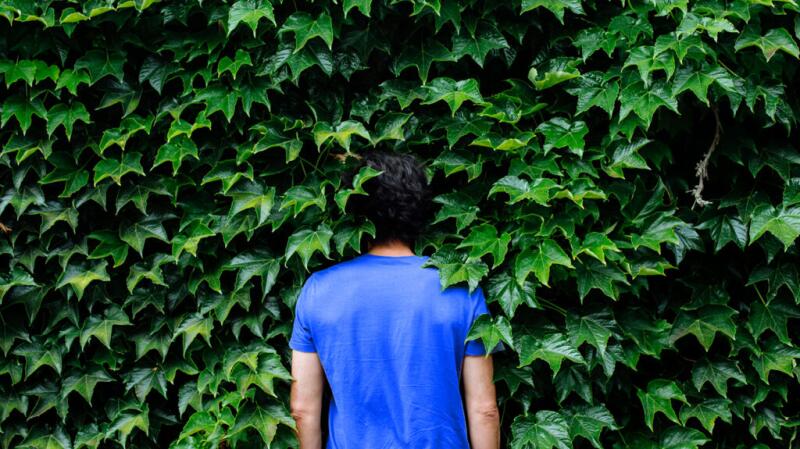 a man is surrounded by ivy