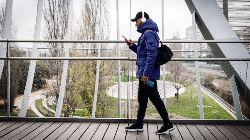 Someone walks while looking at a smartphone