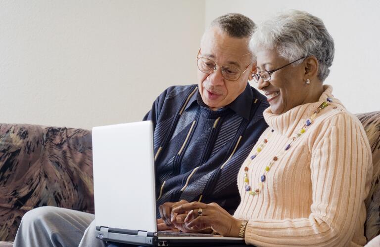 senior-couple-looking-at-laptop