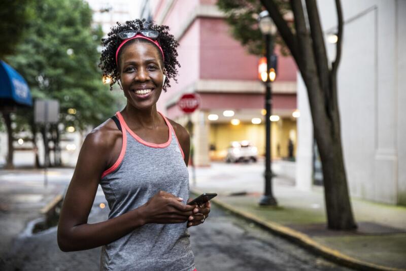 Female runner using mobile device in urban area