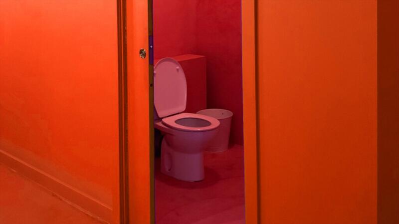 A picture of a toilet viewed through an open door