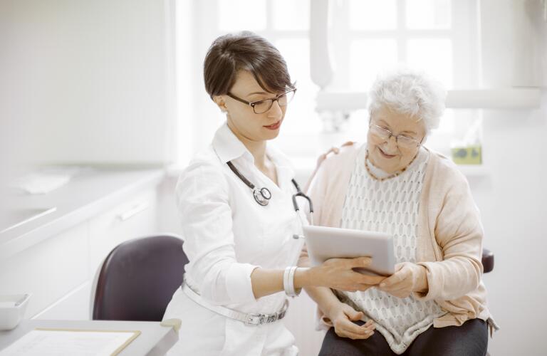Senior Caucasian woman at doctor's office looking at tablet