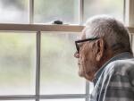 Elderly Caucasian man looking thoughtfully out window