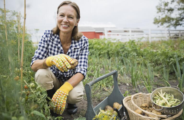 Smiling Woman Kneeling in Garden
