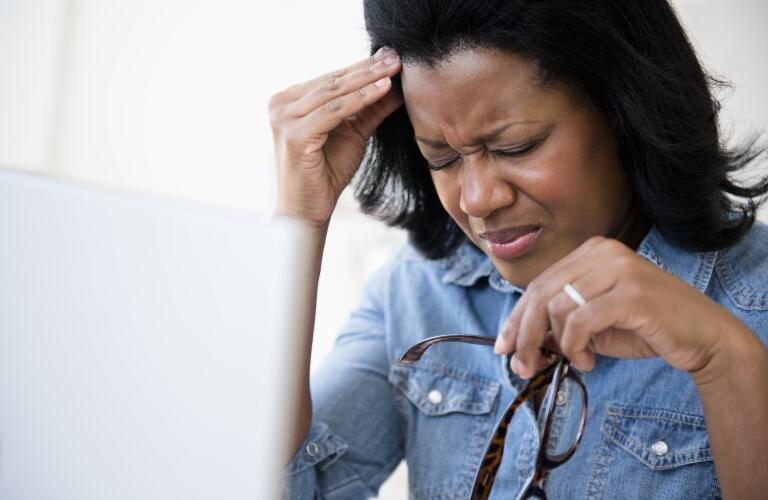 African American woman at computer with headache