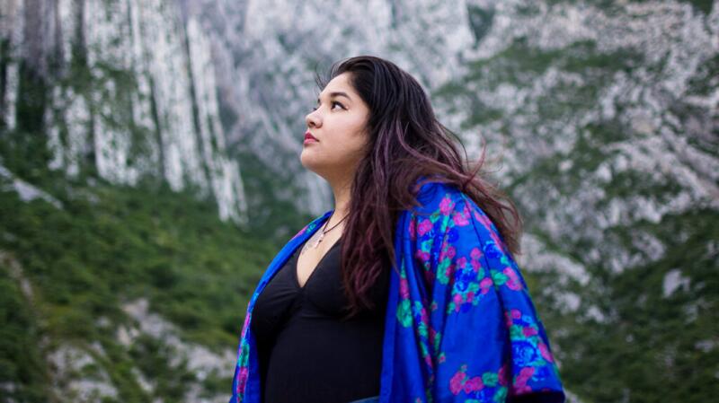 young adult female outside, gazing up at the scenery