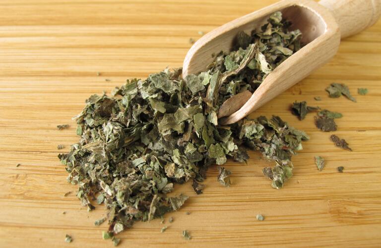 dried butterbur, Petasitidis folium, in wood scoop on wood table