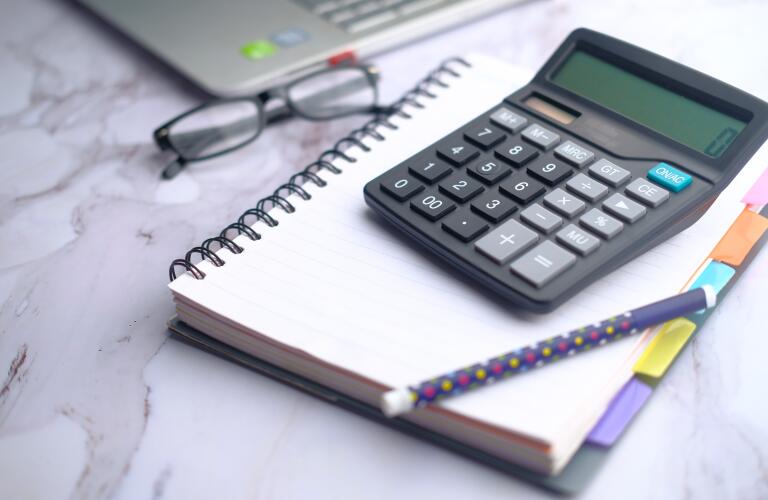 closeup calculator pen notebook eyeglasses and laptop on office table
