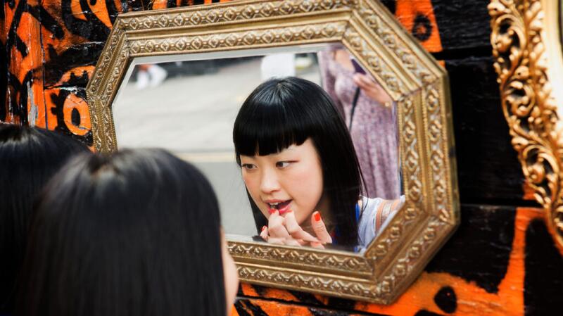 Femme regardant dans un miroir et touchant ses lèvres