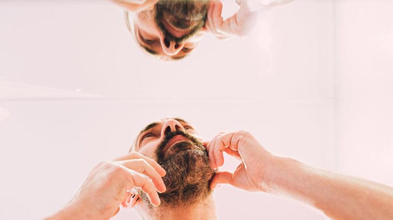 Male studying his face in the mirror