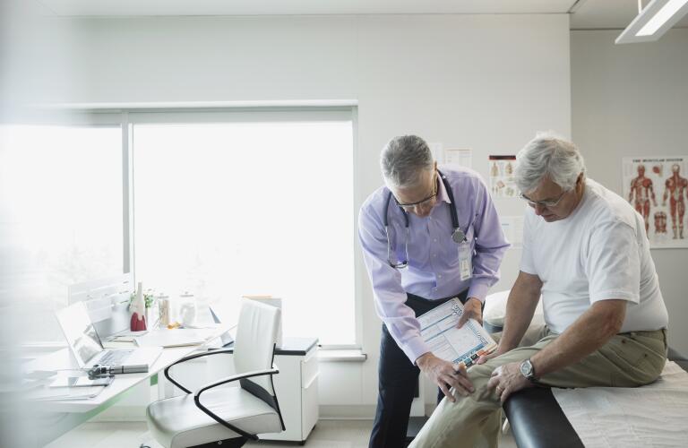 Older man with knee pain with doctor