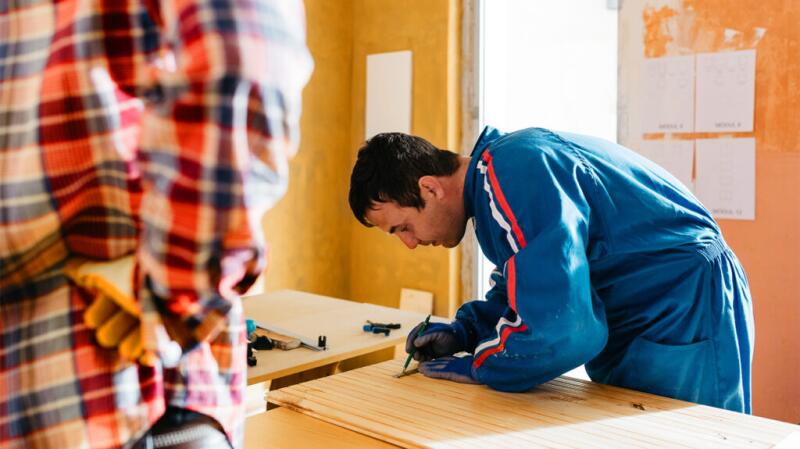 Man bent over doing woodworking
