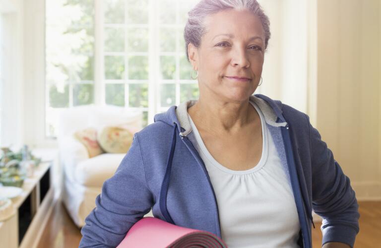 senior-woman-holding-exercise-mat