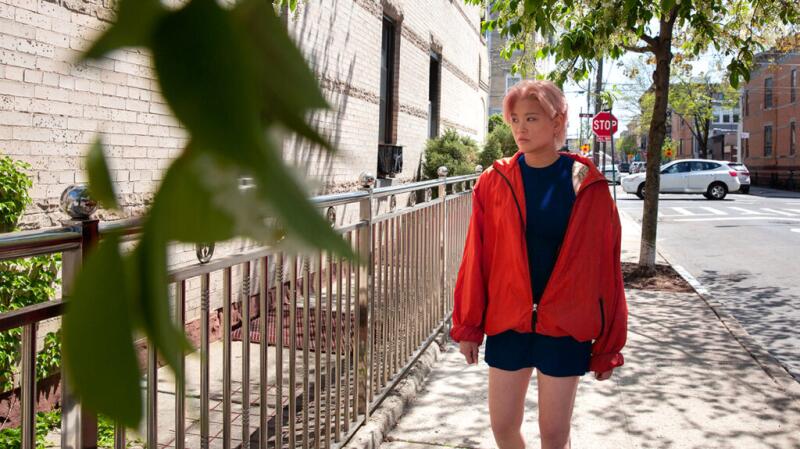 Person in a red coat walking on a sidewalk