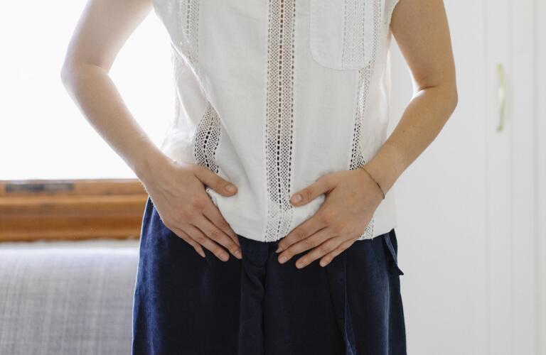 Cropped image of Caucasian woman holding pelvis in pain or discomfort
