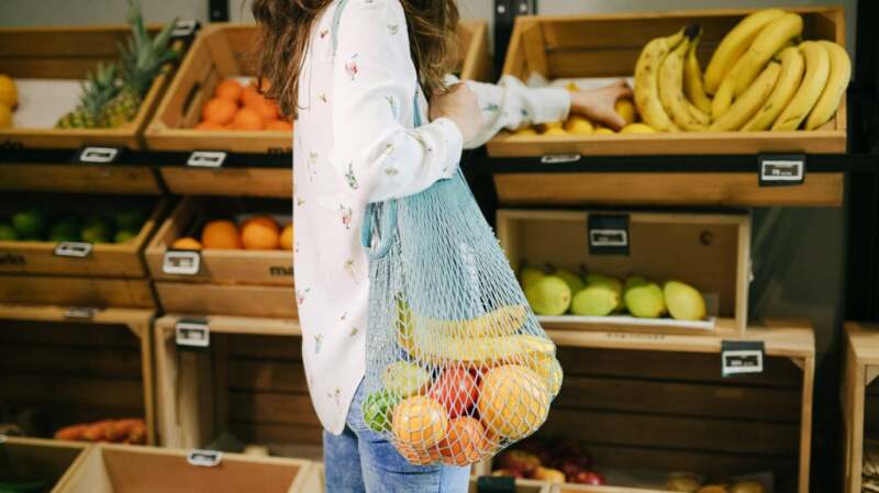 A woman with Crohn's disease is buying fruit at a supermarket