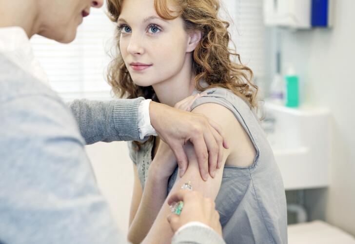 Young Caucasian female patient receiving shot or vaccination